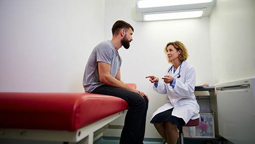 Мужчина разговаривает с врачом в стационаре